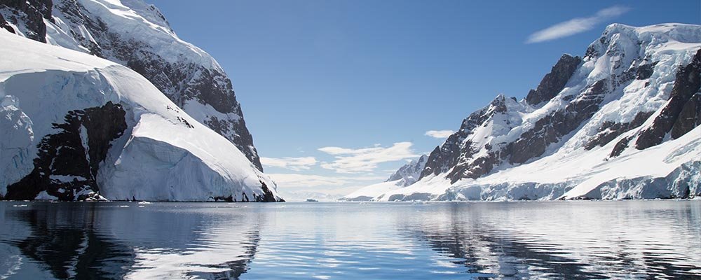 Icy mountains reflecting in the waters of Lemaire Channel Antarctica